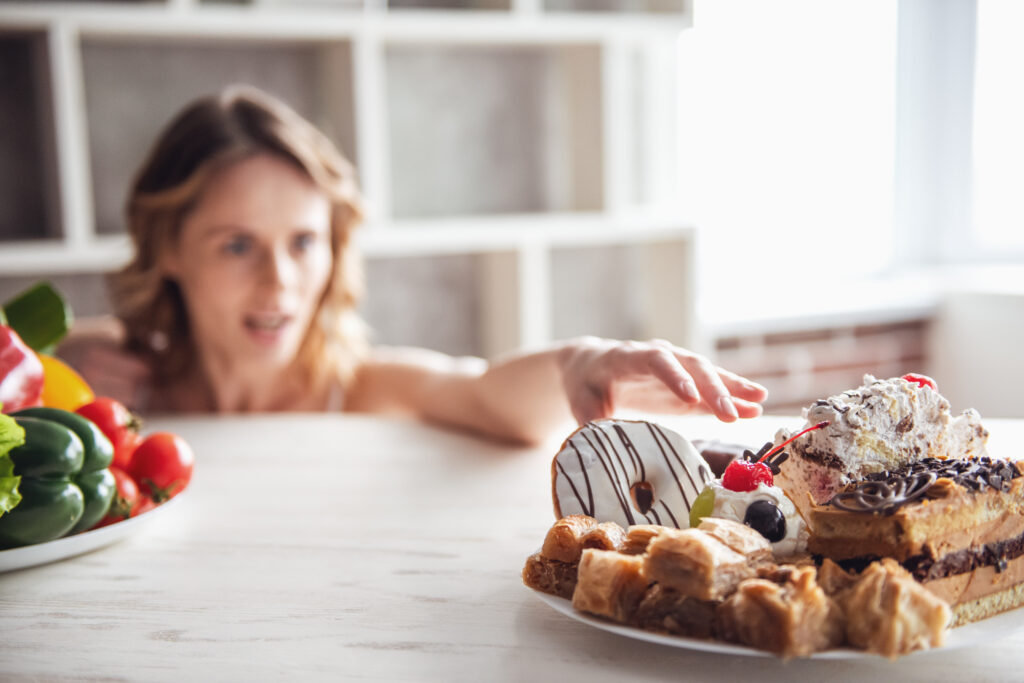 woman with food addiction reaches for sugary hyper pallatable food